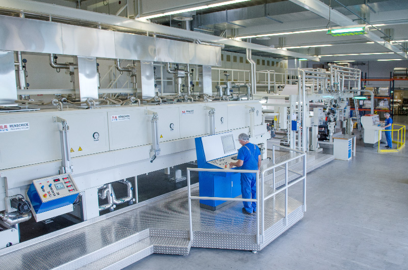 Maschine mit flacher Plattform, in der mitte ist ein Schaltzentrum, an der ein Mann steht